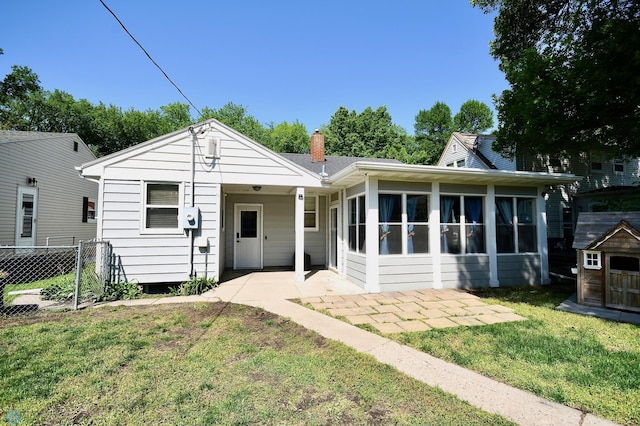 1253 3rd St N, Fargo, ND 58102 - view of front of house featuring a storage shed, a patio area, a sunroom, and a chimney