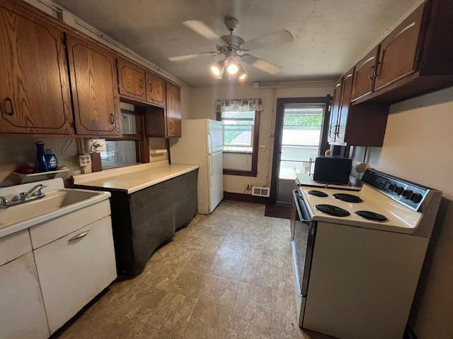2750 330th St, Sterling Twp, WI 54840 - kitchen with white appliances, ceiling fan, light countertops, and light floors