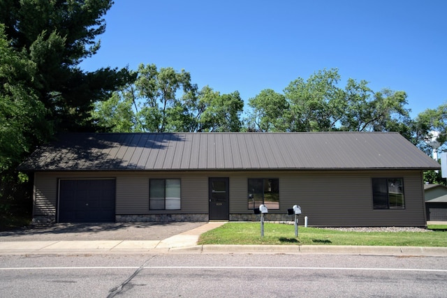 1001 3rd St SW, Crosby, MN 56441 - view of front of house featuring an attached garage, a metal roof, and a front lawn