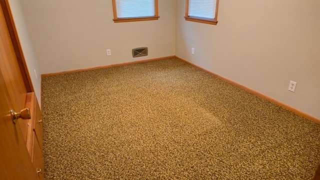 1003 15th St SW, Austin, MN 55912 - empty room featuring carpet flooring and baseboards