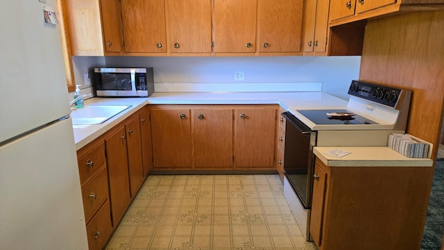 1003 15th St SW, Austin, MN 55912 - kitchen featuring freestanding refrigerator, stainless steel microwave, electric range, and light countertops