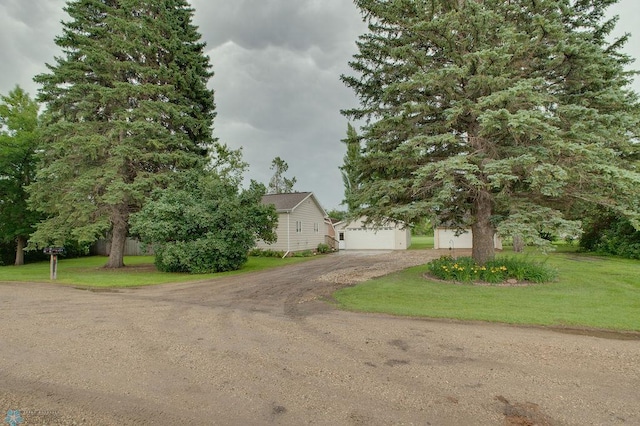 604 2nd Ave S, Kindred, ND 58052 - obstructed view of property featuring driveway, an outbuilding, a garage, and a front yard