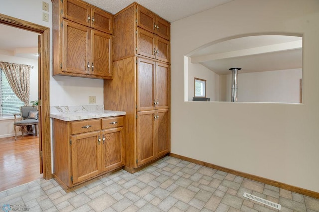 604 2nd Ave S, Kindred, ND 58052 - kitchen with light countertops, brown cabinets, healthy amount of natural light, and arched walkways