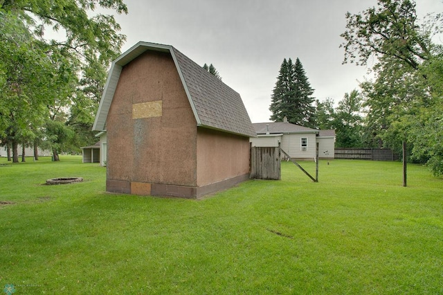 604 2nd Ave S, Kindred, ND 58052 - view of property exterior featuring a shingled roof, a gambrel roof, an outdoor fire pit, and an outbuilding