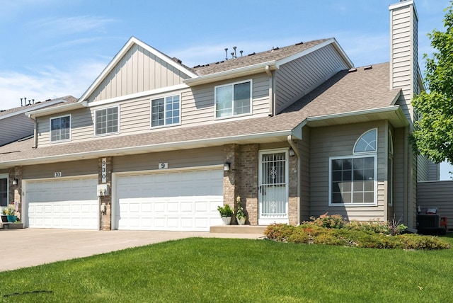 930 106th Ln NW Unit 9Nw, Coon Rapids, MN 55433 - townhome / multi-family property featuring concrete driveway, a front lawn, board and batten siding, and a chimney
