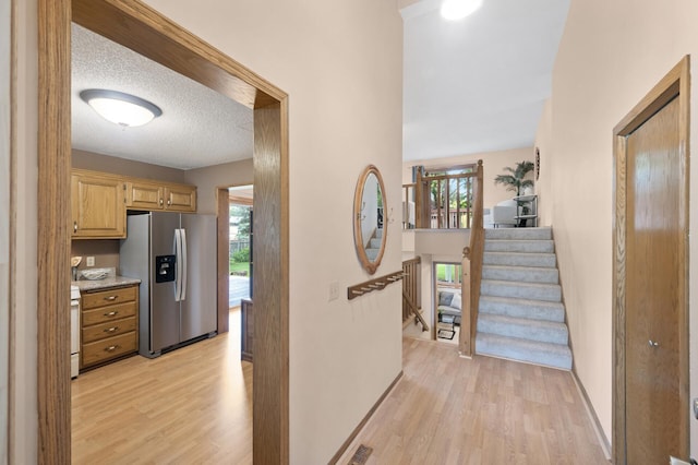 6722 116th Cir, Champlin, MN 55316 - hall featuring light wood-style floors, a textured ceiling, and stairs