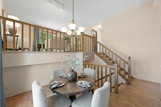 6722 116th Cir, Champlin, MN 55316 - dining room with a chandelier, wood finished floors, stairs, and track lighting
