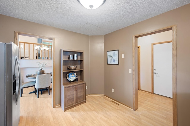 6722 116th Cir, Champlin, MN 55316 - hall with light wood-style flooring, a textured ceiling, and a chandelier