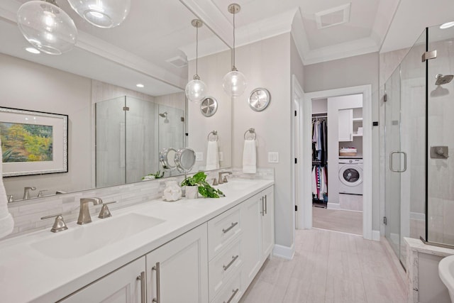 5975 Inland Ln N, Plymouth, MN 55446 - bathroom featuring washer / clothes dryer, a shower stall, double vanity, a walk in closet, and backsplash