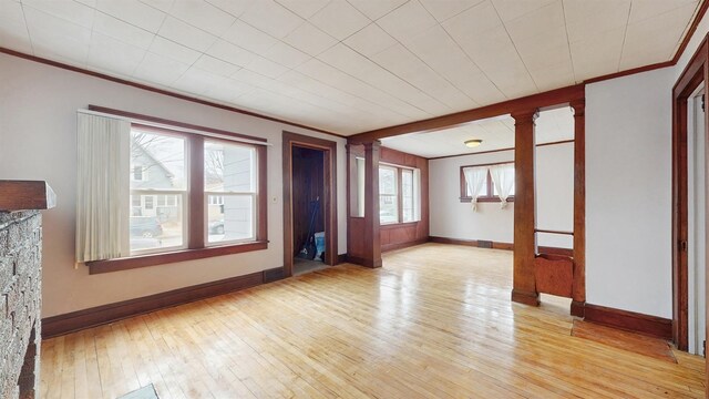1038 23rd Ave SE, Minneapolis, MN 55414 - unfurnished living room with decorative columns, light wood finished floors, and crown molding