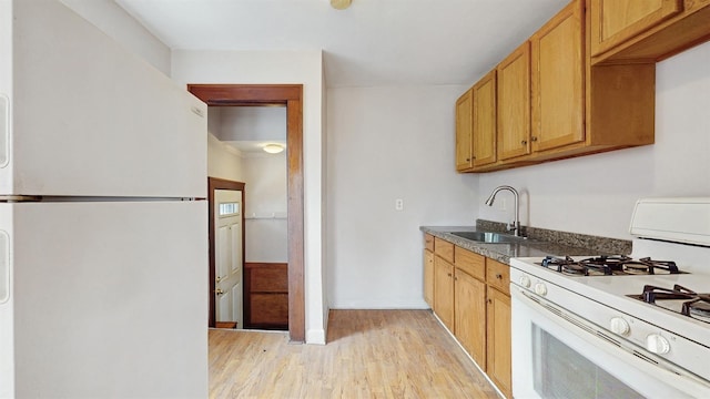 1038 23rd Ave SE, Minneapolis, MN 55414 - kitchen with white appliances, light wood-style floors, and dark countertops