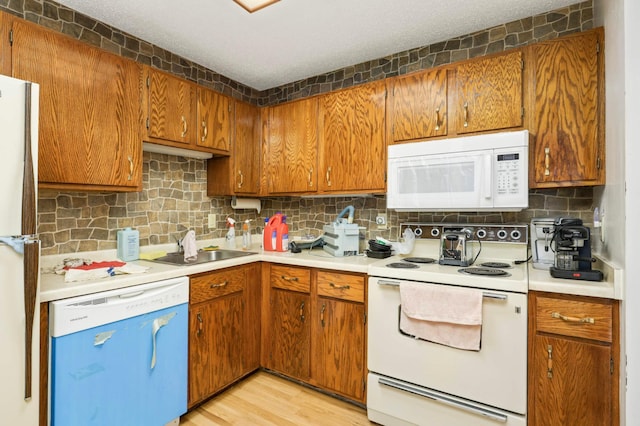 1903 Silver Bell Rd Unit 108, Eagan, MN 55122 - kitchen with white appliances, decorative backsplash, and brown cabinetry