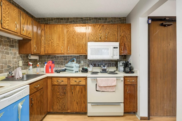 1903 Silver Bell Rd Unit 108, Eagan, MN 55122 - kitchen with white appliances, light wood-type flooring, decorative backsplash, and brown cabinets