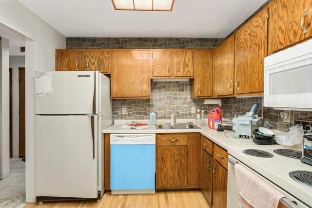 1903 Silver Bell Rd Unit 108, Eagan, MN 55122 - kitchen featuring white appliances, brown cabinets, light countertops, and decorative backsplash