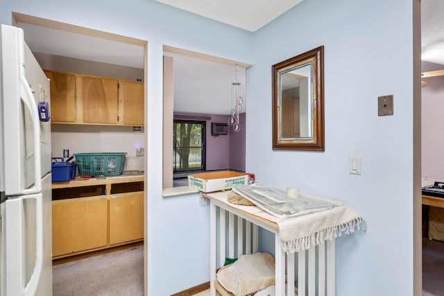 1887 Silver Bell Rd Unit 115, Eagan, MN 55122 - kitchen with freestanding refrigerator, a wall mounted AC, light countertops, and light carpet