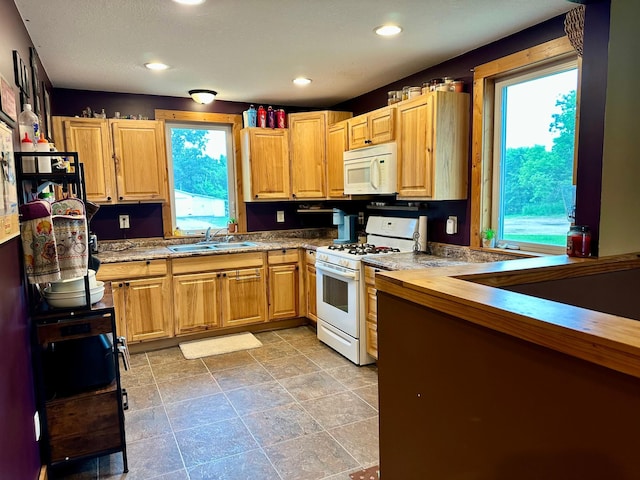 316 2nd St NE, Menahga, MN 56464 - kitchen featuring white appliances, healthy amount of natural light, recessed lighting, and light stone finish floors