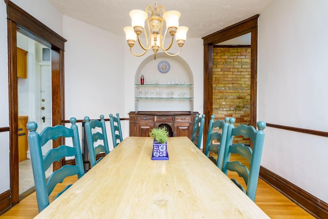 63 Avon St S Unit 36, Saint Paul, MN 55105 - dining area with a chandelier, wood finished floors, and a textured ceiling