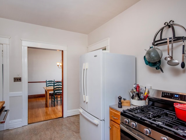 63 Avon St S Unit 36, Saint Paul, MN 55105 - kitchen featuring stainless steel range with gas cooktop, freestanding refrigerator, a chandelier, and light countertops