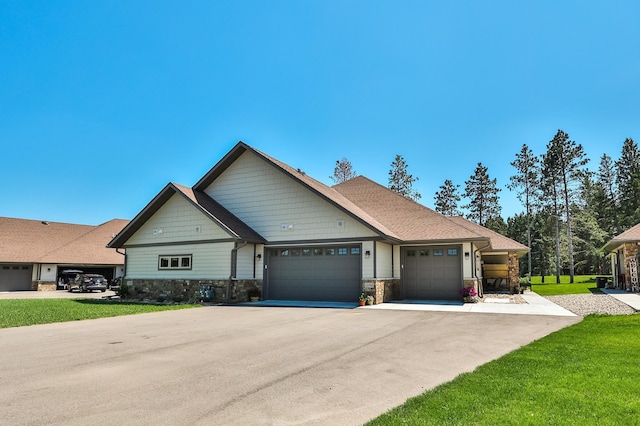 12245 Blueberry Loop, Menahga, MN 56464 - view of front of home featuring stone siding, a garage, asphalt driveway, and a front yard