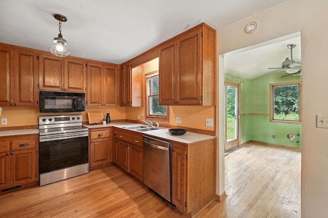 6398 Osman Ave N, Oak Park Heights, MN 55082 - kitchen with appliances with stainless steel finishes, light wood-style floors, light countertops, brown cabinets, and lofted ceiling