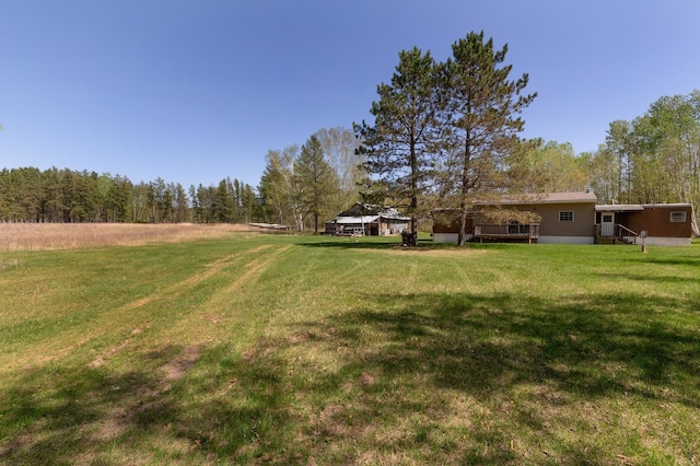 1042 48th Ave SW, Backus, MN 56435 - view of green lawn with a wooden deck and a forest view