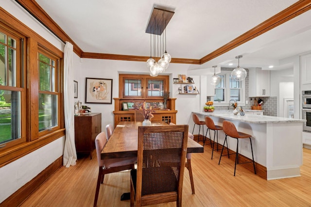 4708 Pleasant Ave, Minneapolis, MN 55419 - dining room with light wood finished floors, a chandelier, and crown molding