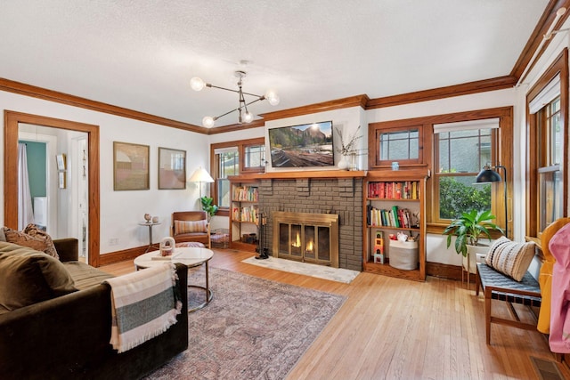 4708 Pleasant Ave, Minneapolis, MN 55419 - living room featuring ornamental molding, a fireplace, a chandelier, hardwood / wood-style flooring, and a textured ceiling
