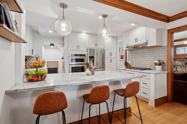 4708 Pleasant Ave, Minneapolis, MN 55419 - kitchen featuring appliances with stainless steel finishes, a peninsula, white cabinetry, decorative backsplash, and ornamental molding
