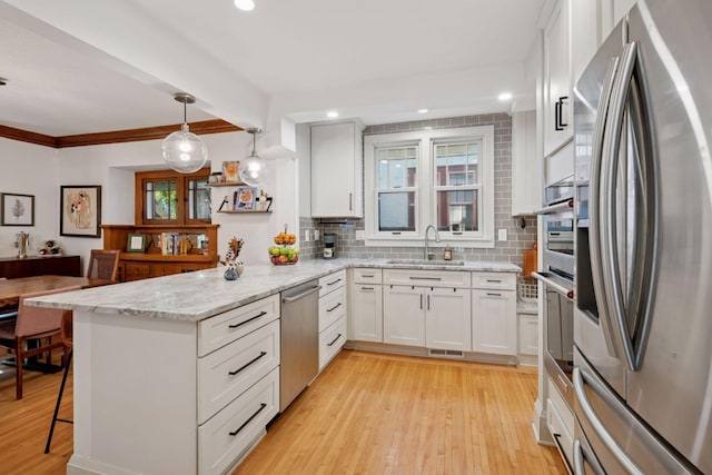4708 Pleasant Ave, Minneapolis, MN 55419 - kitchen with stainless steel appliances, a peninsula, tasteful backsplash, light wood-style floors, and white cabinets