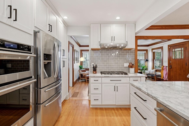 4708 Pleasant Ave, Minneapolis, MN 55419 - kitchen featuring stainless steel appliances, crown molding, light wood finished floors, white cabinetry, and tasteful backsplash