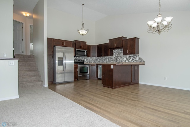 1381 Westport Beach Way W, Fargo, ND 58078 - kitchen with appliances with stainless steel finishes, a chandelier, decorative light fixtures, tasteful backsplash, and high vaulted ceiling