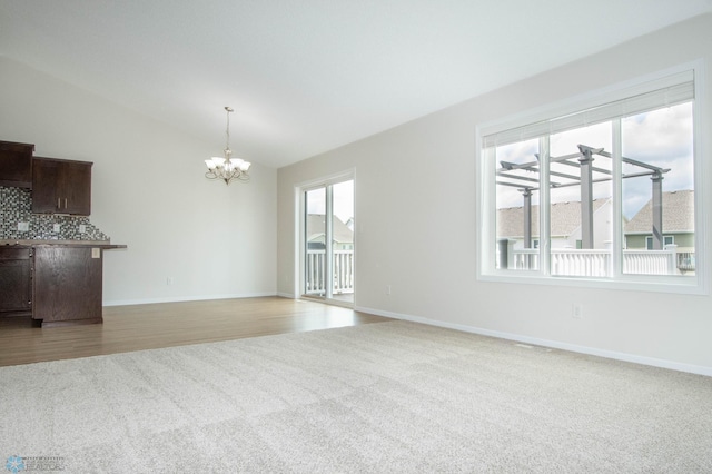 1381 Westport Beach Way W, Fargo, ND 58078 - unfurnished living room featuring carpet floors, a chandelier, and lofted ceiling