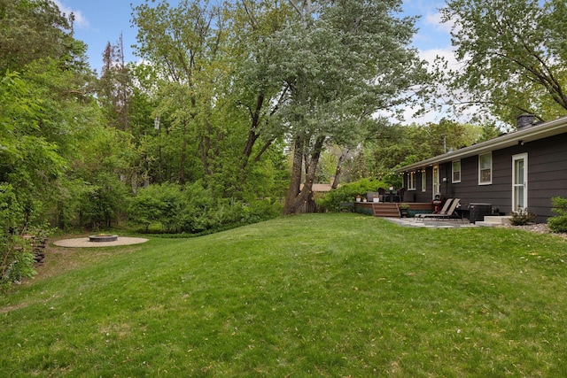 18201 Kathleene Dr, Minnetonka, MN 55345 - view of grassy yard with an outdoor fire pit, a patio, and a deck