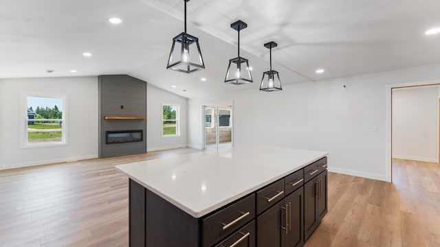 322 Old Glory Dr NE, Alexandria, MN 56308 - kitchen featuring vaulted ceiling, open floor plan, a fireplace, decorative light fixtures, and light wood-style floors
