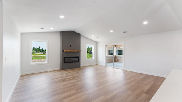 322 Old Glory Dr NE, Alexandria, MN 56308 - unfurnished living room with a large fireplace, light wood-type flooring, lofted ceiling, and recessed lighting