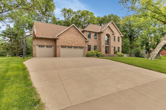 617 17th St N, Sartell, MN 56377 - view of front of house with brick siding, an attached garage, a front yard, and driveway