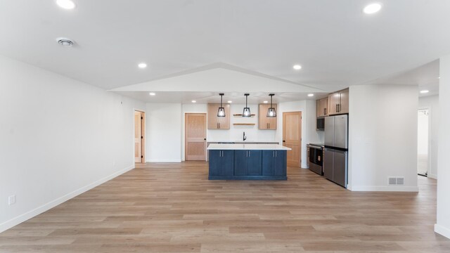 324 Old Glory Dr NE, Alexandria, MN 56308 - kitchen featuring stainless steel appliances, recessed lighting, light countertops, open floor plan, and light wood finished floors
