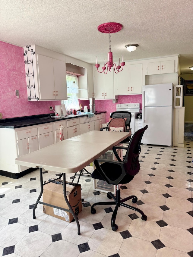 413 3rd Ave SE, Baudette, MN 56623 - kitchen with white appliances, white cabinetry, dark countertops, a textured ceiling, and decorative backsplash