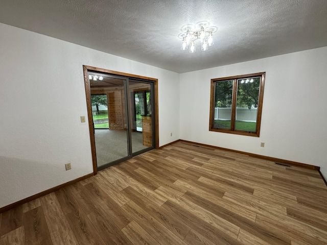 605 Arbor Ct, Marshall, MN 56258 - unfurnished room featuring wood finished floors and a textured ceiling