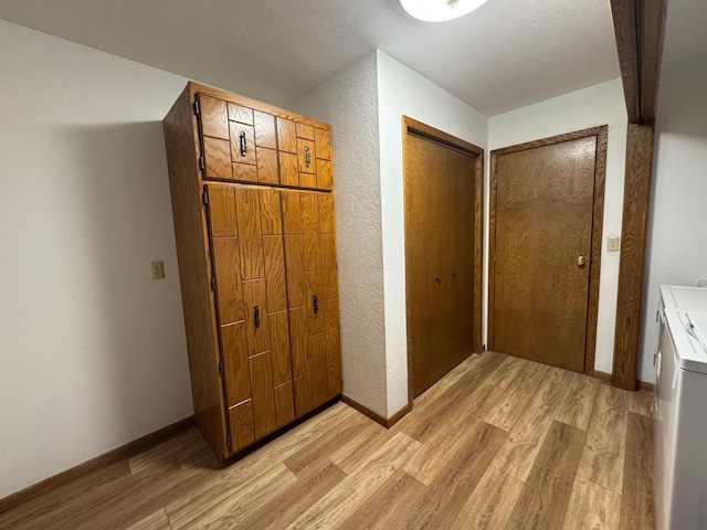 605 Arbor Ct, Marshall, MN 56258 - corridor featuring light wood-type flooring, a textured wall, and washing machine and clothes dryer