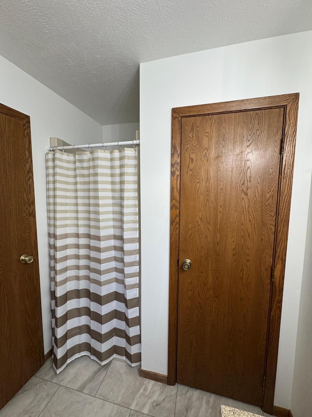 605 Arbor Ct, Marshall, MN 56258 - bathroom featuring a textured ceiling and curtained shower