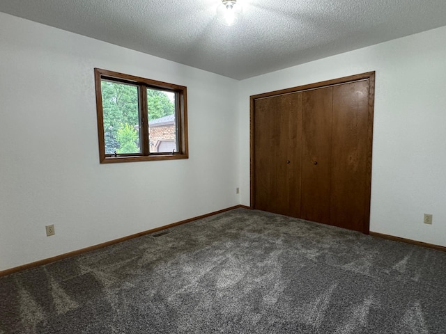 605 Arbor Ct, Marshall, MN 56258 - unfurnished bedroom with carpet floors, a closet, and a textured ceiling