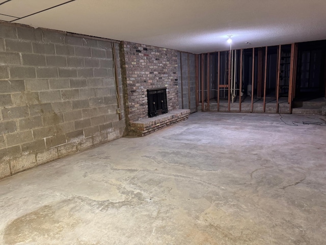 605 Arbor Ct, Marshall, MN 56258 - finished basement featuring a brick fireplace, a textured ceiling, and concrete block wall