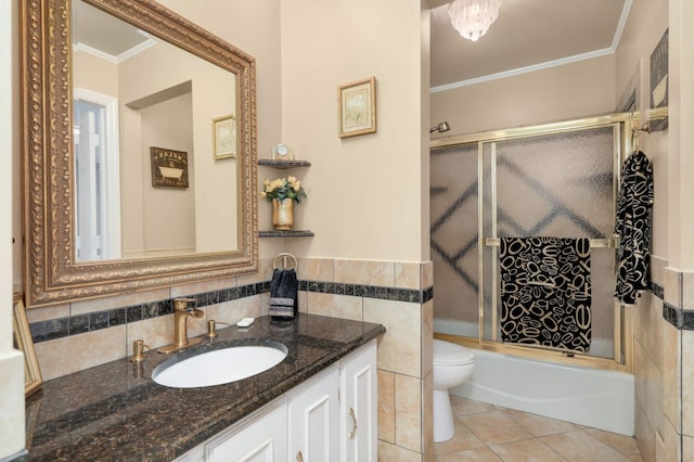 2217 73rd Ct N, Brooklyn Park, MN 55444 - full bathroom with crown molding, vanity, bath / shower combo with glass door, tile walls, and tile patterned flooring