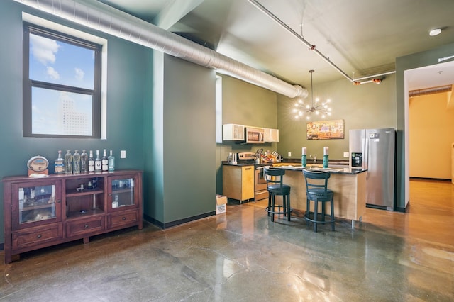 350 Saint Peter St Unit 1110, Saint Paul, MN 55102 - kitchen featuring stainless steel appliances, dark countertops, a chandelier, decorative light fixtures, and a kitchen breakfast bar