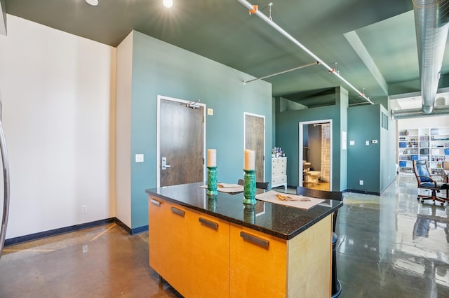 350 Saint Peter St Unit 1110, Saint Paul, MN 55102 - kitchen featuring finished concrete floors, a center island, and dark stone countertops