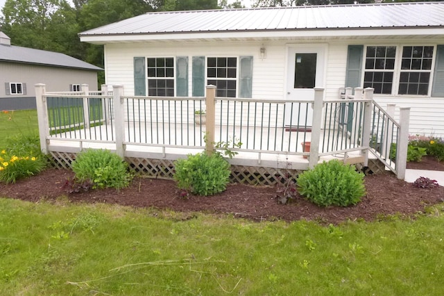 N6217 Kirk Rd, Durand, WI 54736 - rear view of house featuring a wooden deck, a lawn, and a metal roof
