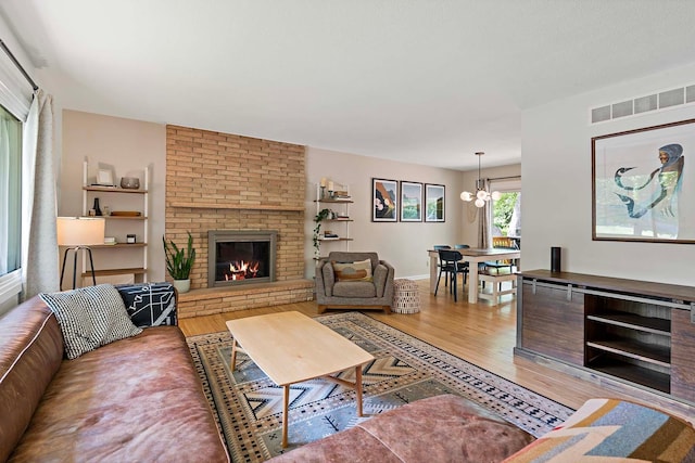 941 Cannon Ave, Shoreview, MN 55126 - living area with light wood-type flooring, a brick fireplace, and a chandelier