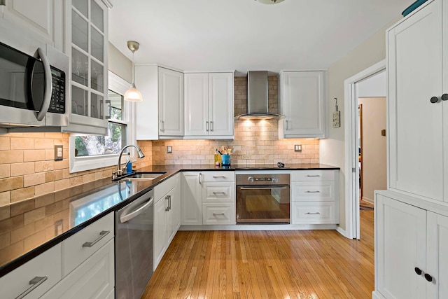 941 Cannon Ave, Shoreview, MN 55126 - kitchen with appliances with stainless steel finishes, wall chimney range hood, dark countertops, light wood-style floors, and white cabinetry