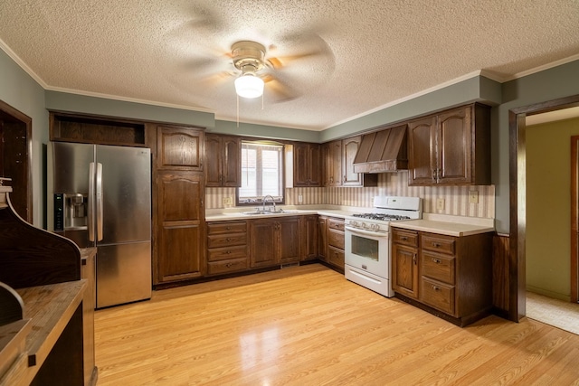 421 Moore St, Blue Earth, MN 56013 - kitchen with white range with gas cooktop, custom range hood, stainless steel fridge with ice dispenser, a ceiling fan, and ornamental molding